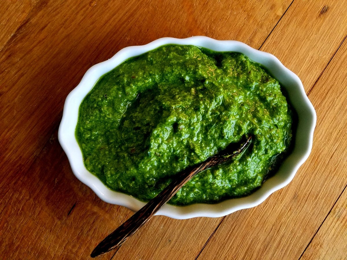 green ramp pesto in white bowl with wooden spoon