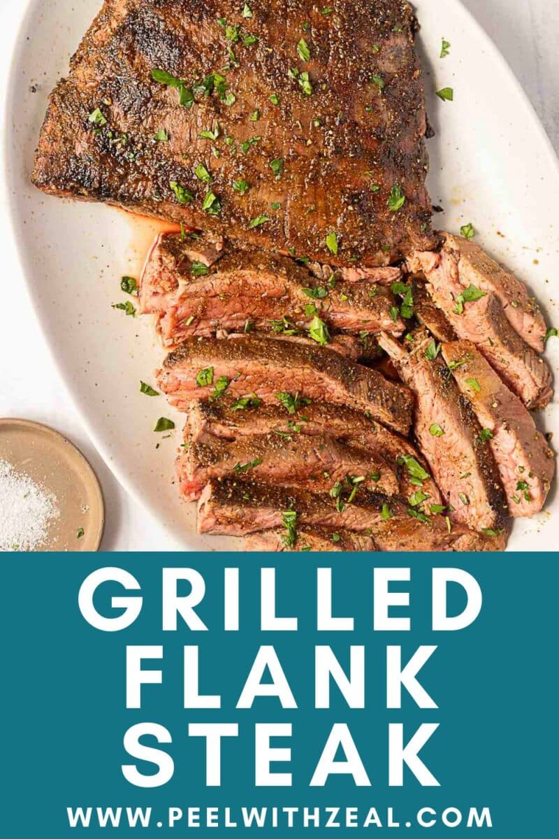 Spice crusted grilled flank steak sliced and garnished with chopped herbs on a white platter, served with a side of salt. Website URL “peelwithzeal.com” displayed below.