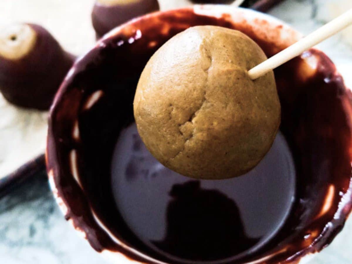 Dipping the peanut butter ball into the melted chocolate.