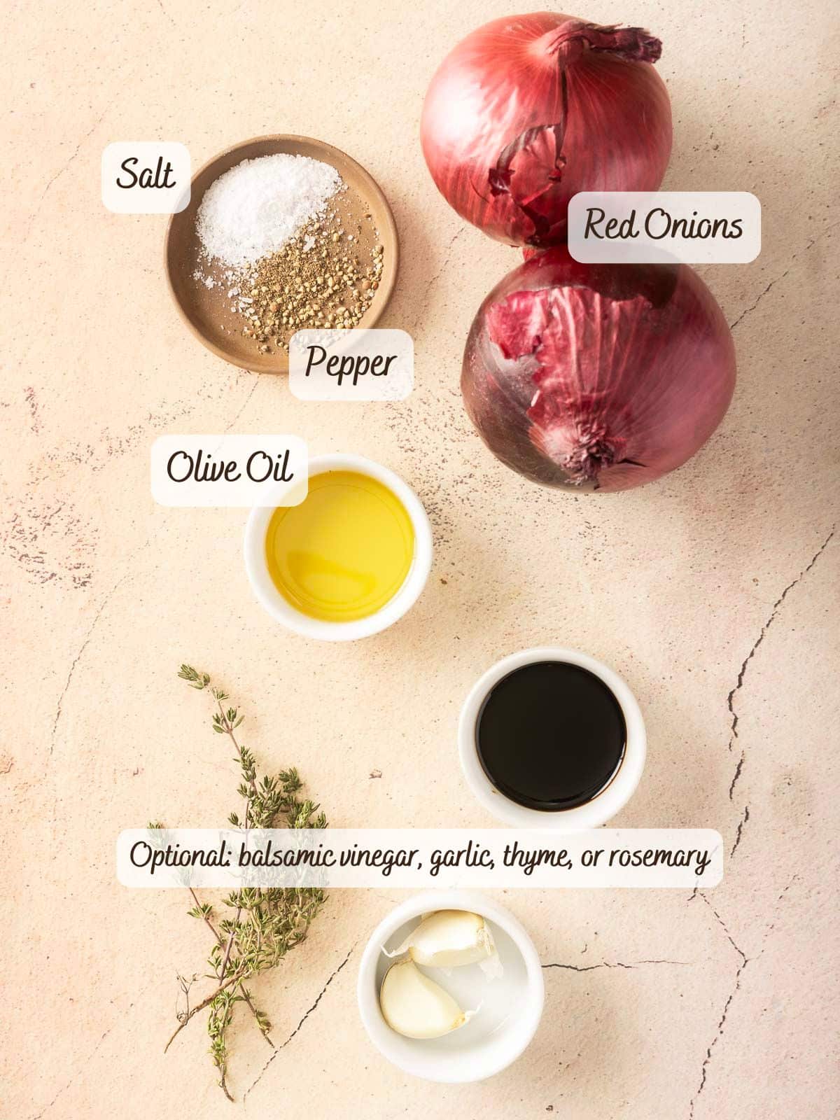 Roasted red onions, olive oil, salt, and pepper adorn the kitchen counter. Optional garlic, balsamic vinegar, and herbs are waiting to join the mix.