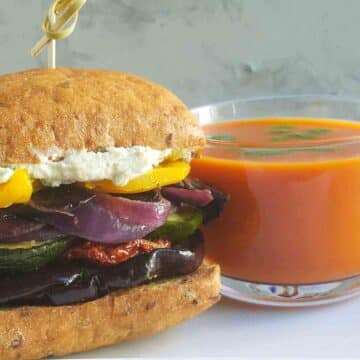 roasted vegetable sandwich next to a cup of soup.