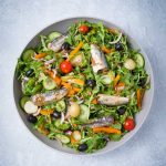 green salad with sardines in bowl