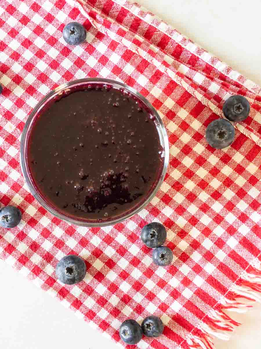 blueberry syrup in bowl on gingham napkin