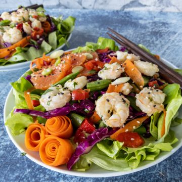 colorful sesame shrimp salad with chopsticks on concrete counter