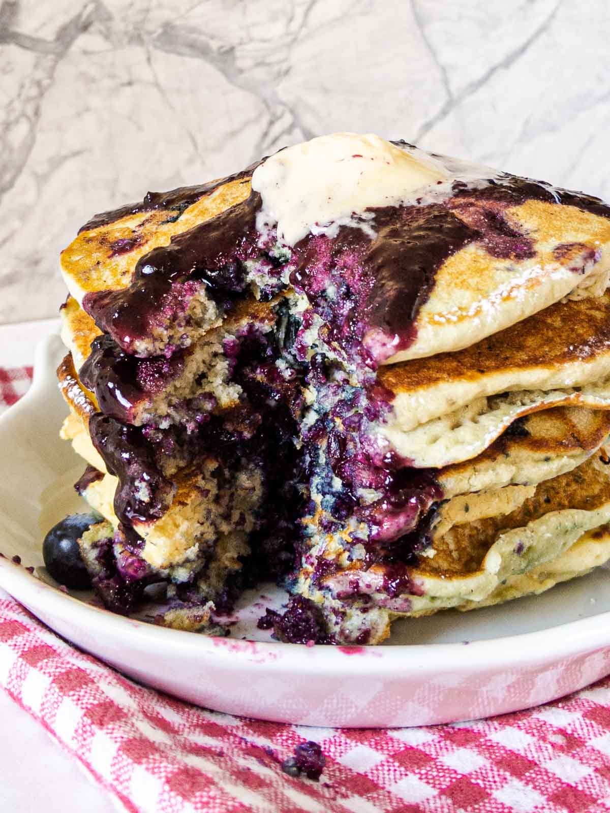 stack of blueberry pancakes with bite missing
