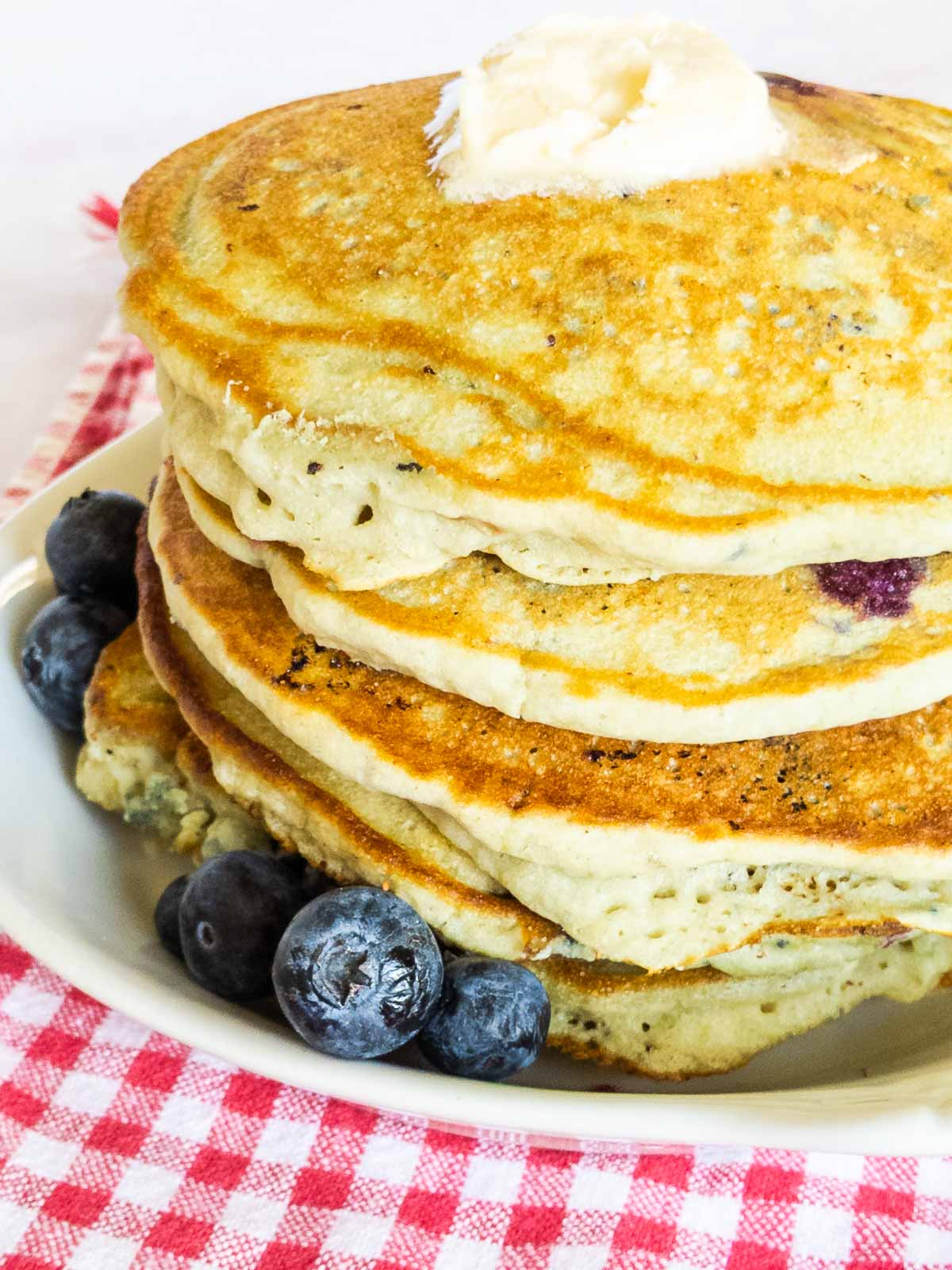 stack of gluten free pancakes with butter and blueberries