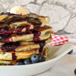 stack of blueberry cakes with blueberry sauce