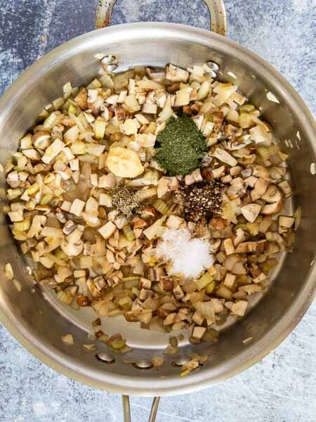 Adding herbs to the pan.