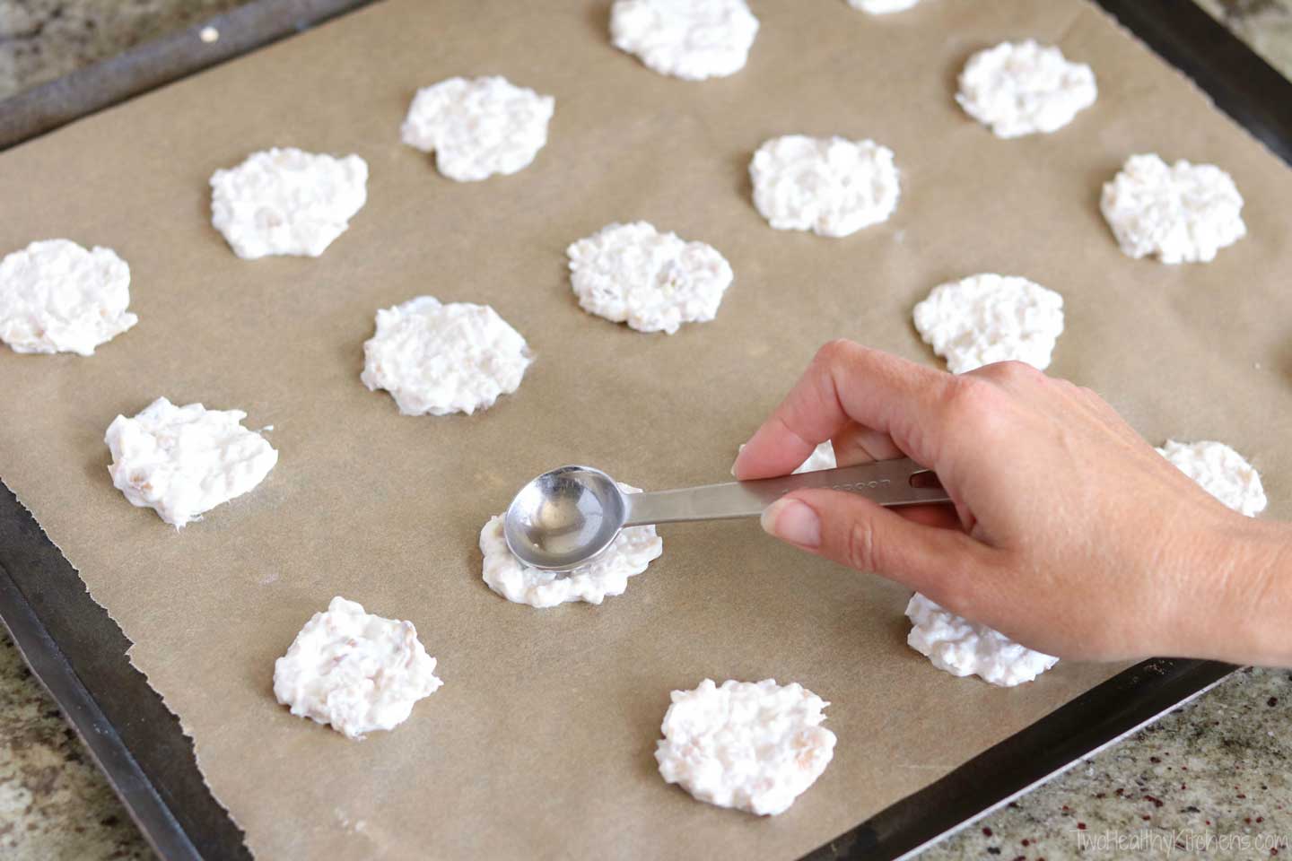 scooping frozen dog treats onto sheet pan