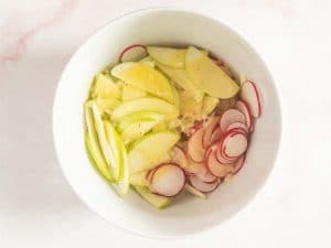apples and radishes in bowl with dressing