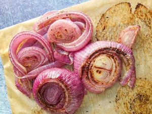 roasted red onions on parchment paper