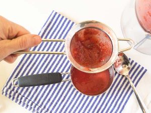 straining strawberry puree