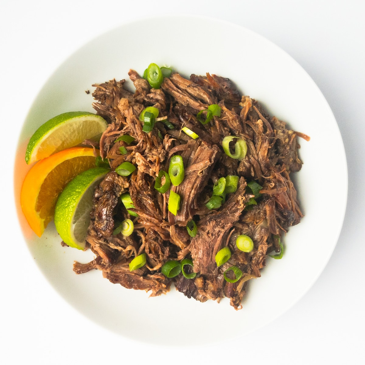 shredded beef in bowl with citrus