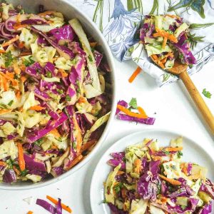 spicy coleslaw on a plate next to a serving bowl