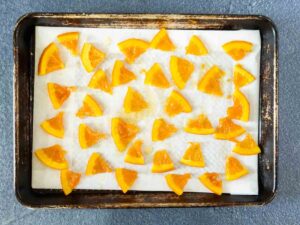 candied oranges cooling on parchment