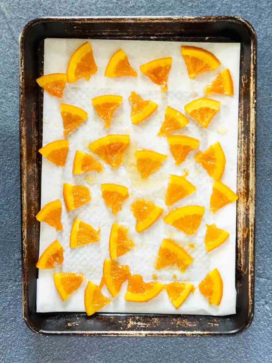 candied oranges cooling on parchment