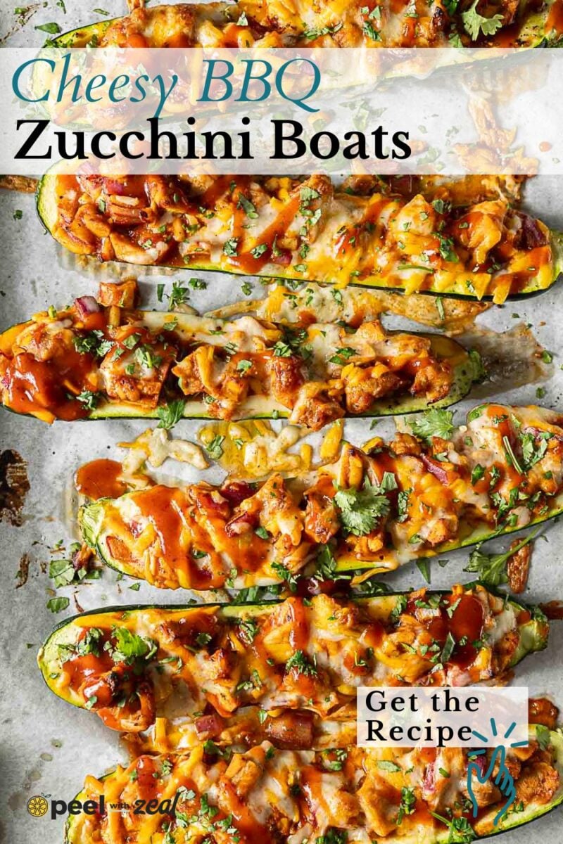 Chicken Zucchini Boats: Baked zucchini halves filled with chopped vegetables, chicken, melted cheese, BBQ sauce, and herbs on a parchment-lined baking sheet.