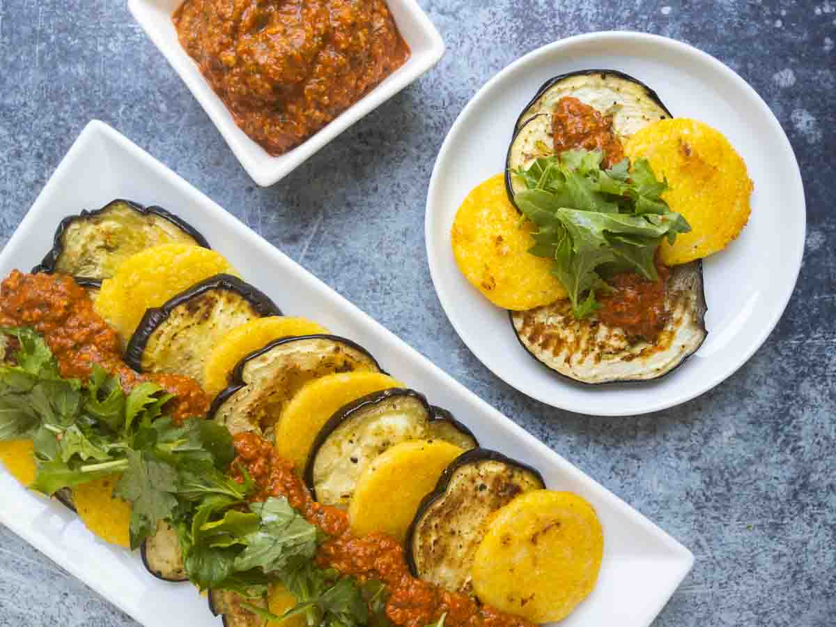 polenta cakes with sauce on platter and small serving on plate