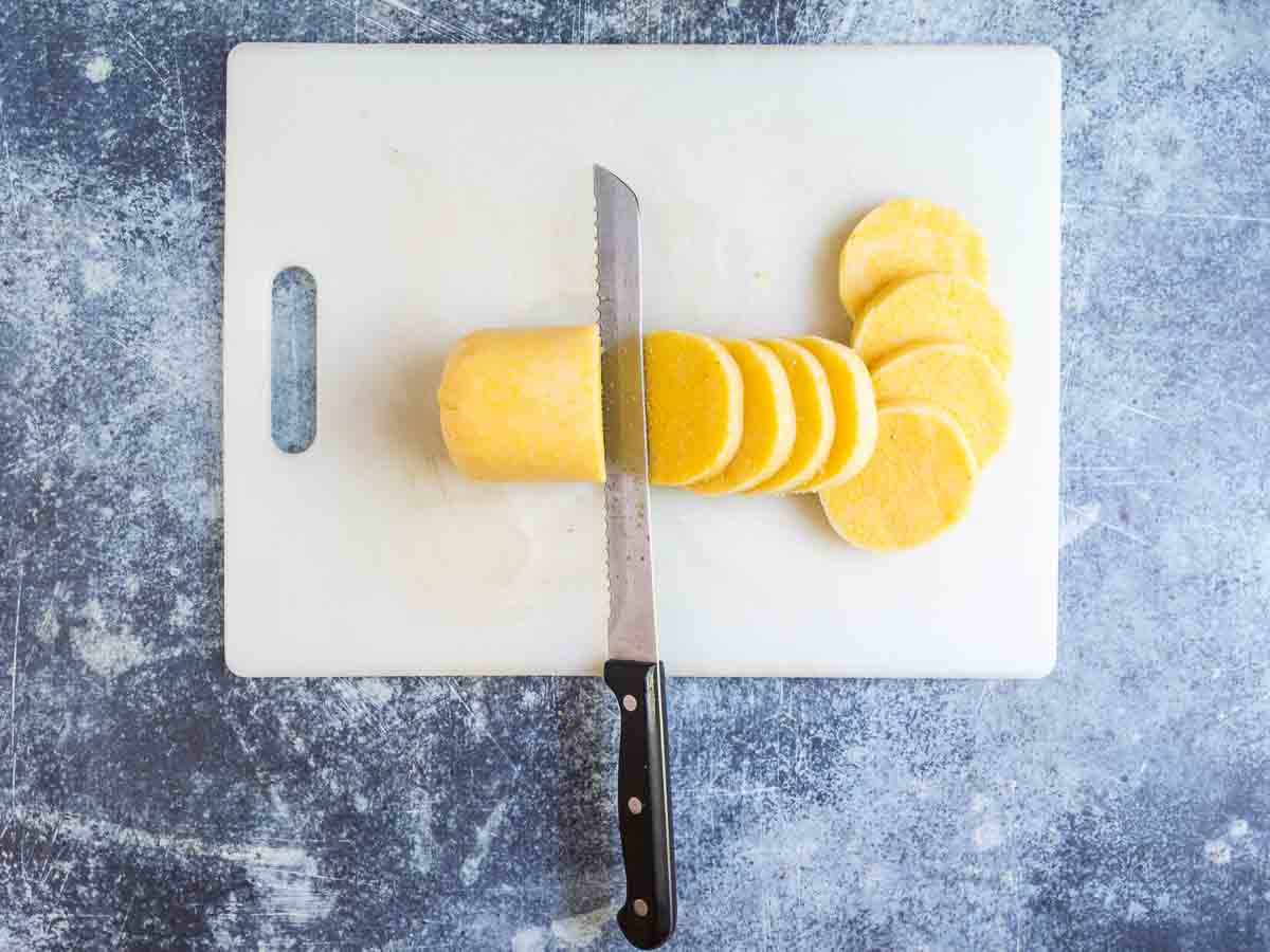 slicing tube polenta into rounds