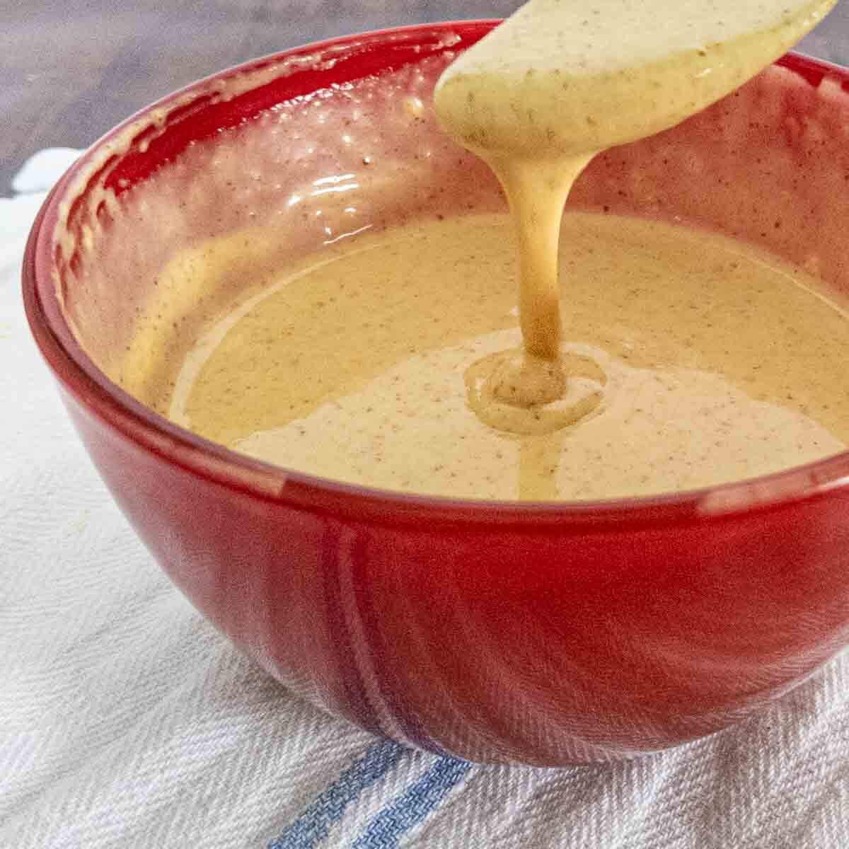 honey mustard sauce in red bowl with spoon