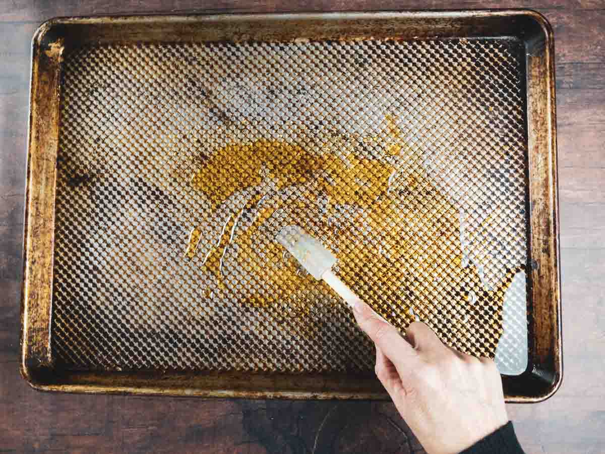 mixing warm honey and olive oil on a sheet pan