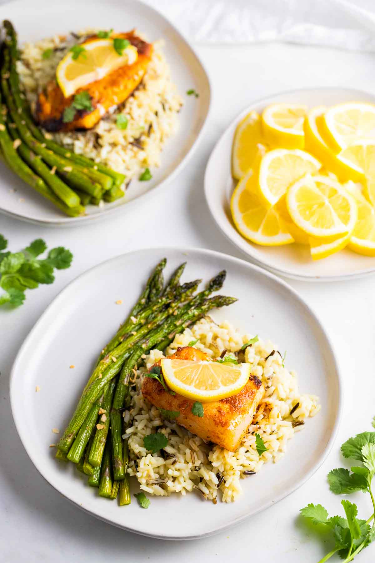 Cajun cod on plate with rice and asparagus.