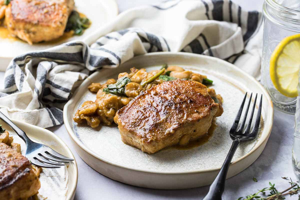 pork chop with white beans on a plate