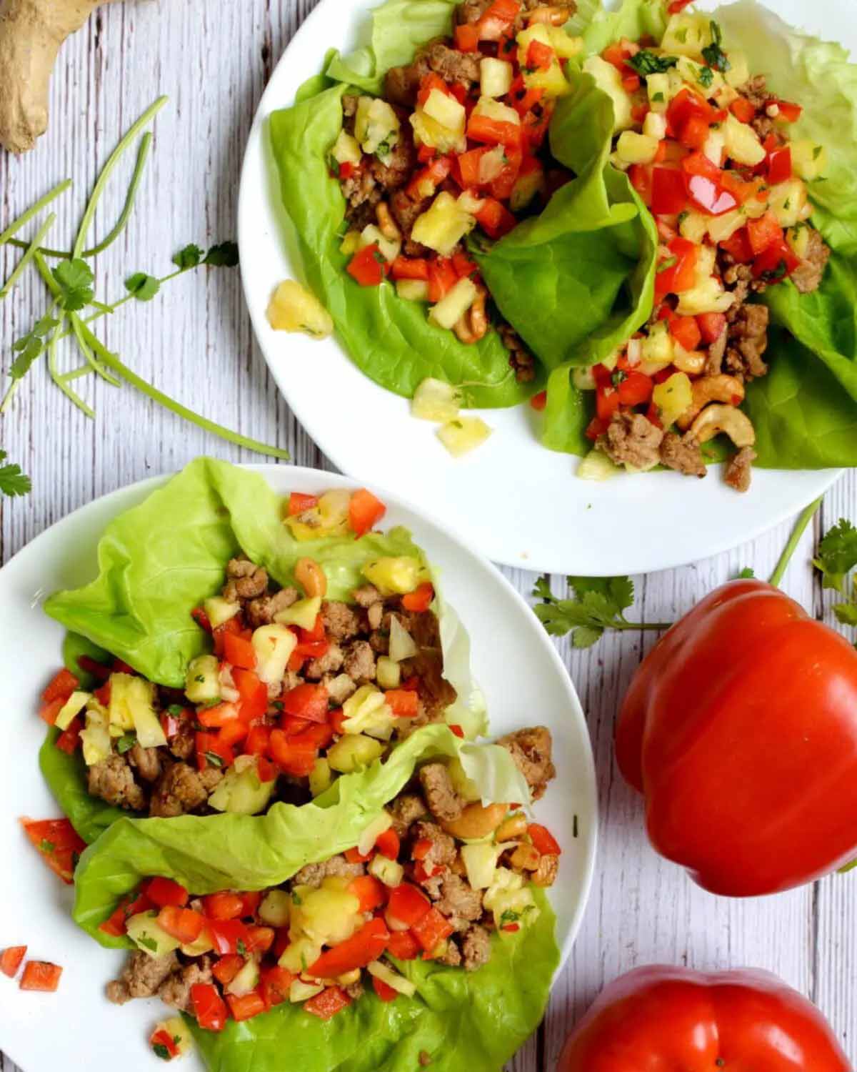 gluten free turkey lettuces wraps on plates with red peppers