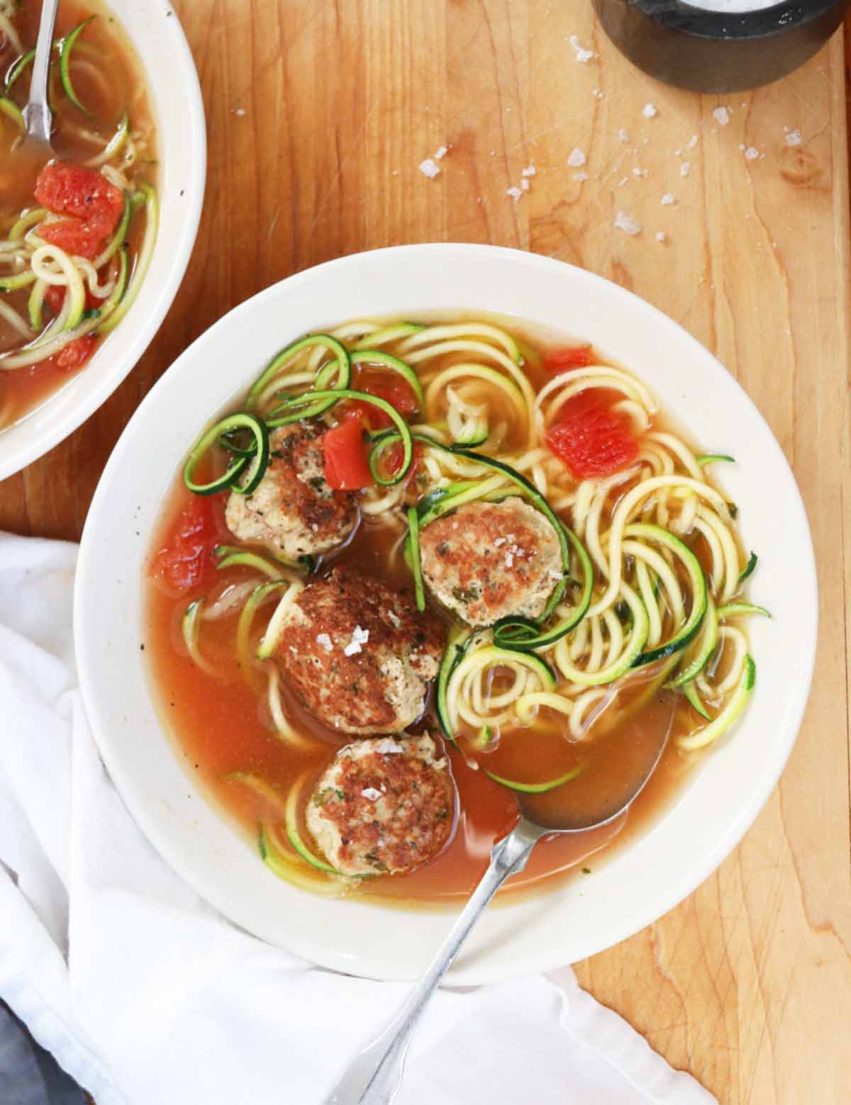 turkey zoodle soup in a bowl with spoon