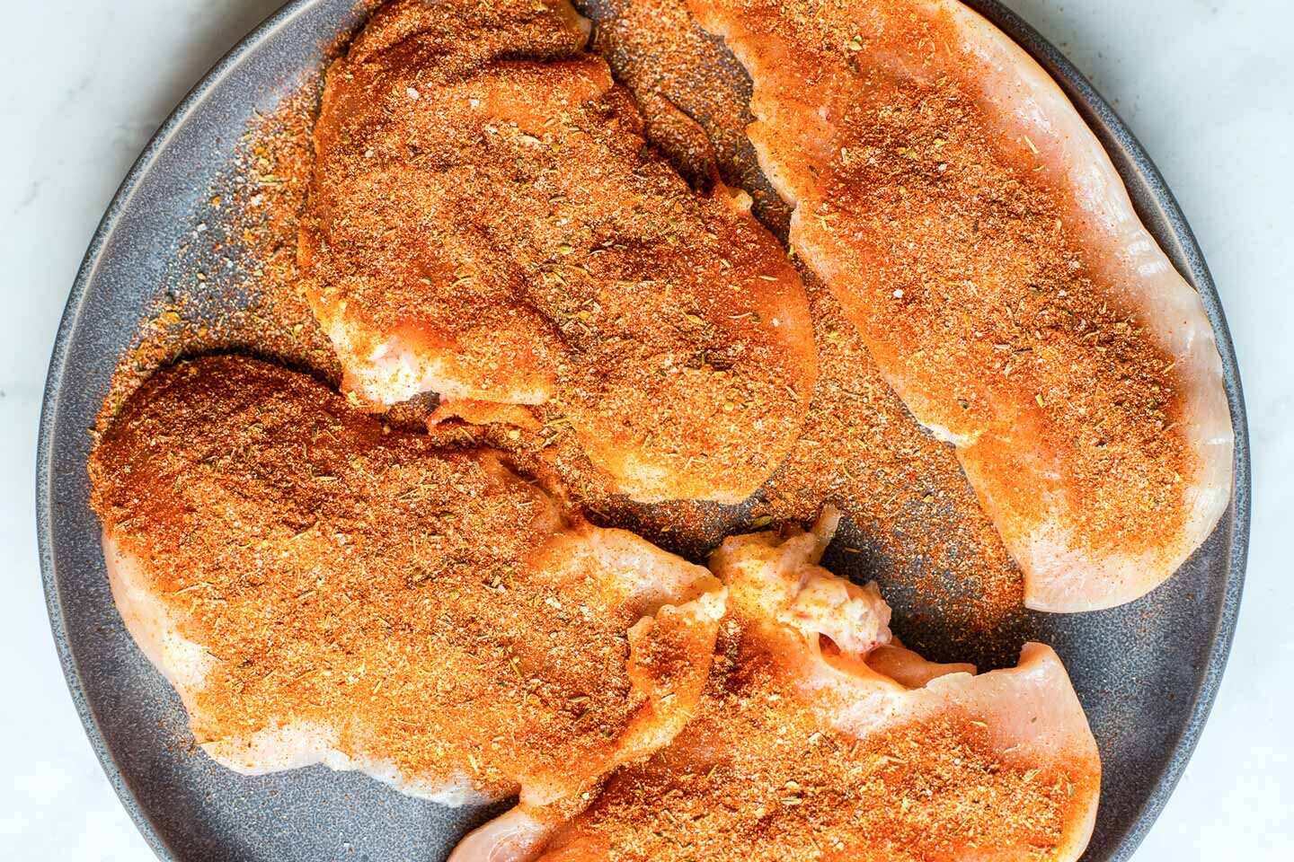 Chicken with cajun seasoning before cooking.