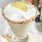 coconut lime margarita with a toasted coconut rim and lime garnish