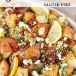 roasted potatoes in serving dish topped with feta