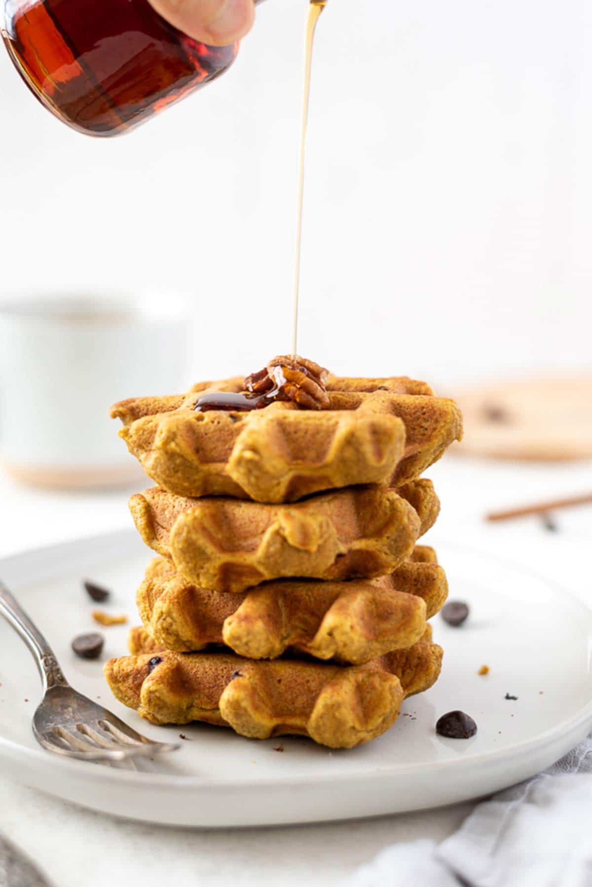 syrup being pour on oat waffles