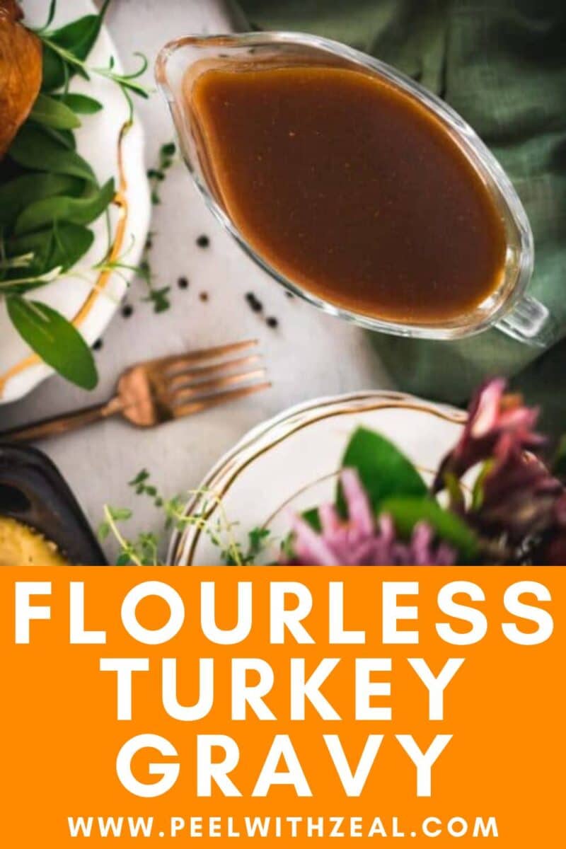 A glass gravy boat filled with brown gluten-free turkey gravy sits on a table set with plates, cutlery, and green leafy garnishes.