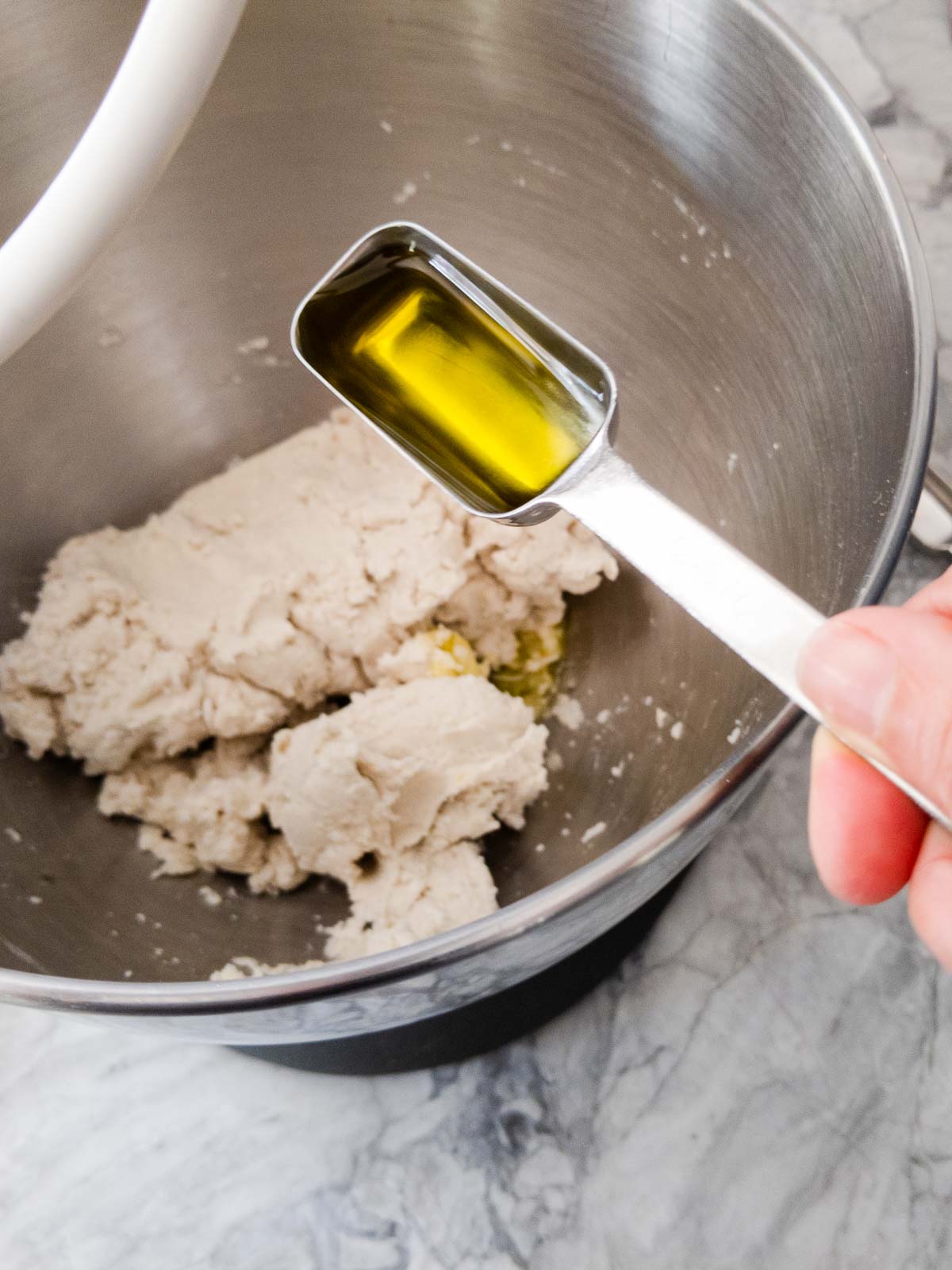 adding olive oil to dough