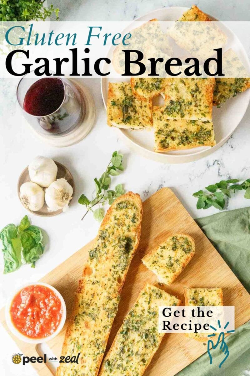 Sliced gluten free garlic bread on a wooden board with a bowl of marinara sauce, fresh garlic, greens, and a glass of red wine on a marble surface. The perfect gluten free appetizer for any occasion.