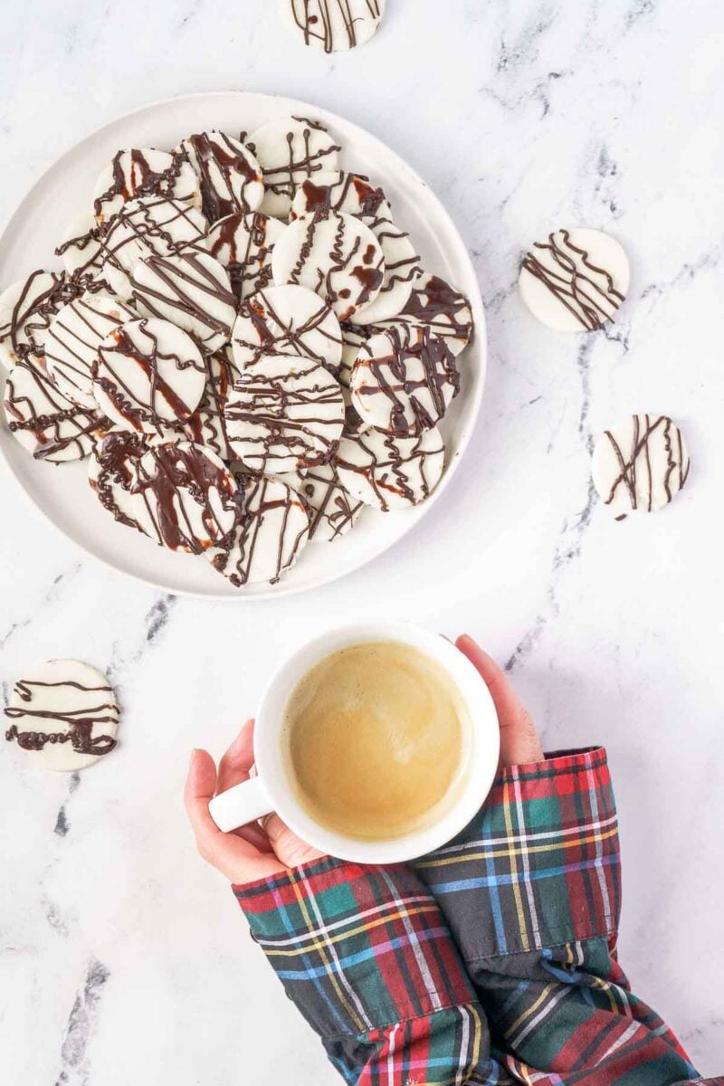 person having coffee with plate of Christmas candy
