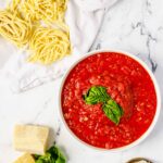 sauce in bowl with fresh pasta and parm on counter