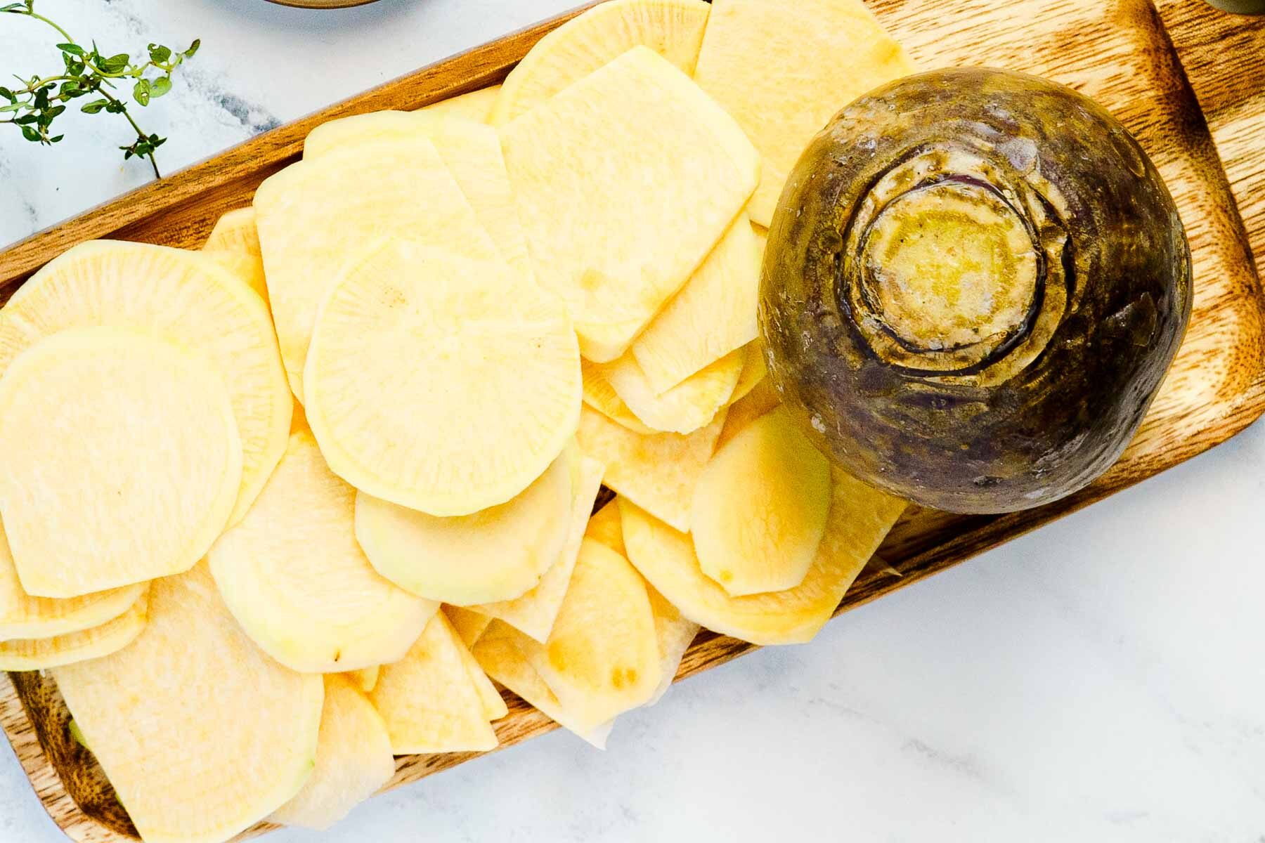 thinly sliced rutabaga on cutting board