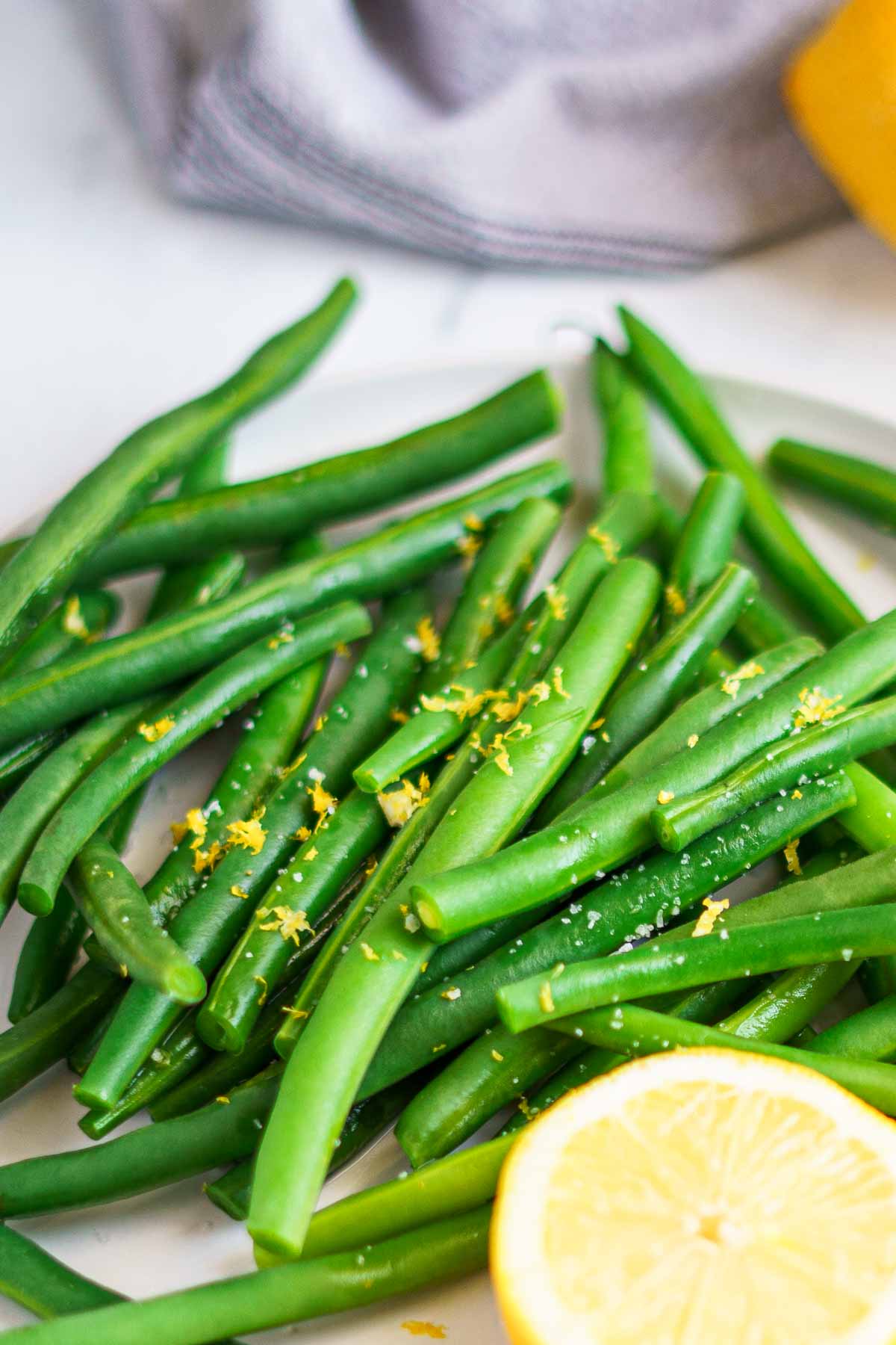 blanched green beans on a plate with lemon zest