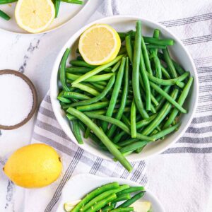 blanched green beans in a bowl with a lemon