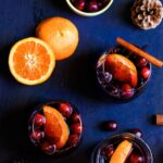 glasses of spiced wine on a counter with orange slices