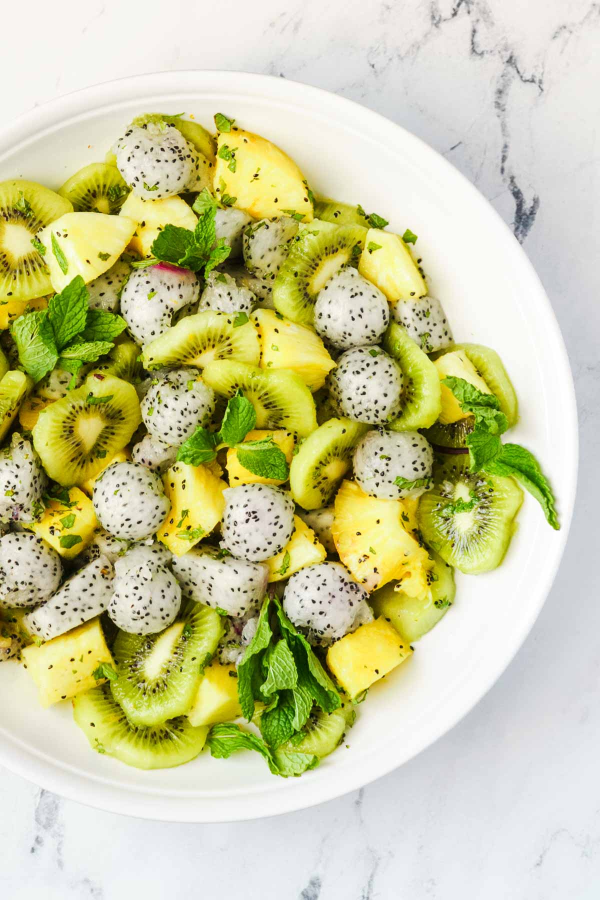 combined dragon fruit salad with dressing and fresh mint