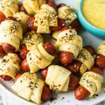mini pigs in a blanket on plate with dipping sauce