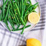 blanched green beans on a plate with lemon