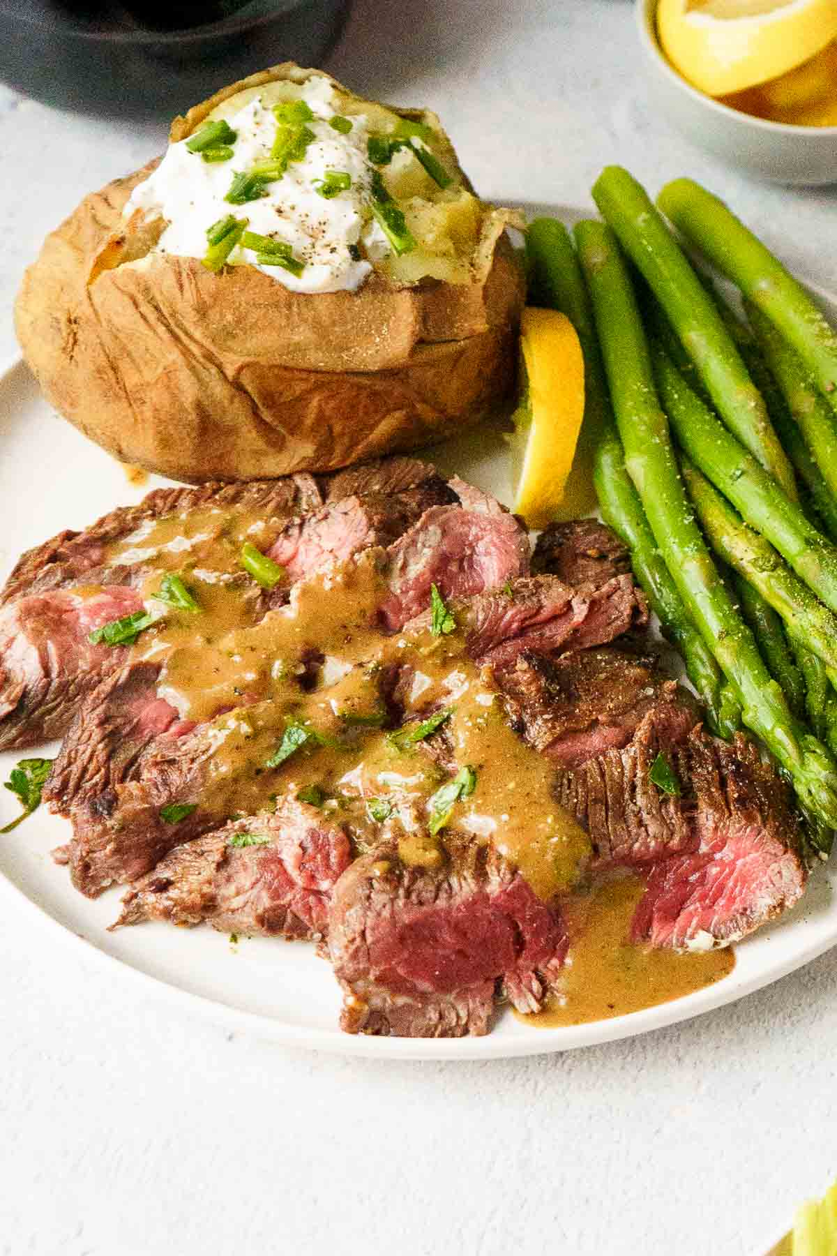bavette steaks served with a baked potato and asparagus