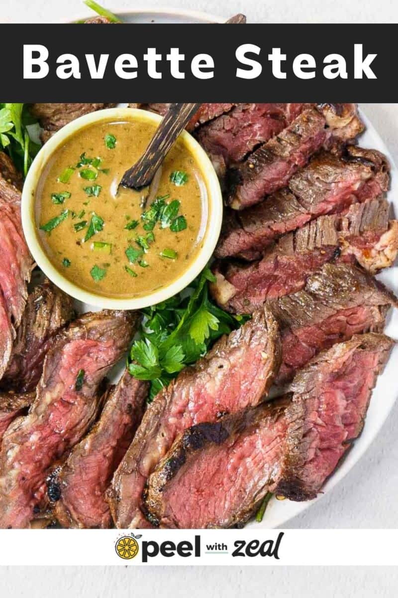 A plate of sliced bavette steak served with a bowl of sauce and garnished with fresh parsley makes for a flavorful and satisfying meal.