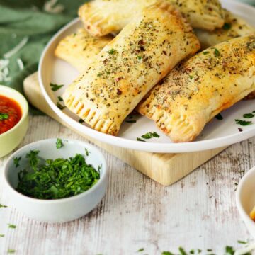 gluten free pizza rolls on a plate with parsley and pizza sauce