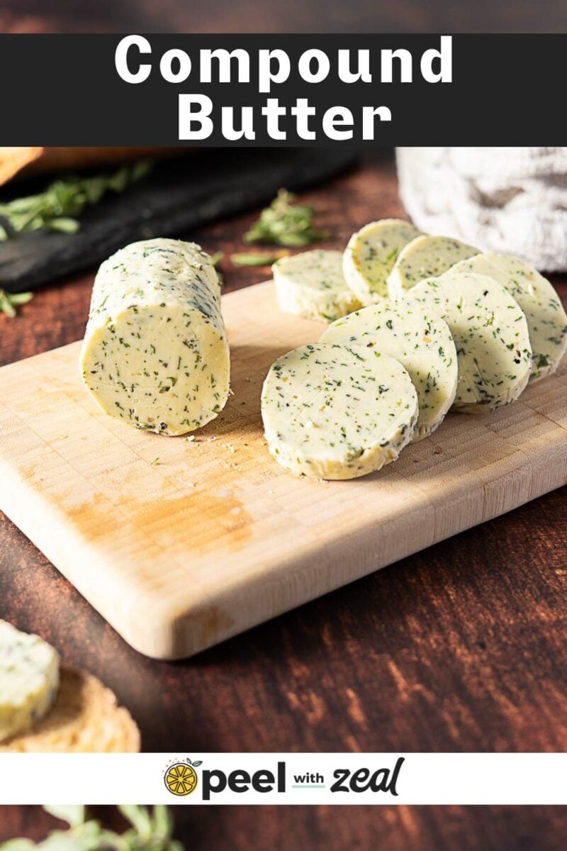 Sliced Herb and Garlic Compound Butter with fresh herbs on a wooden cutting board, alongside a bread slice in the background.