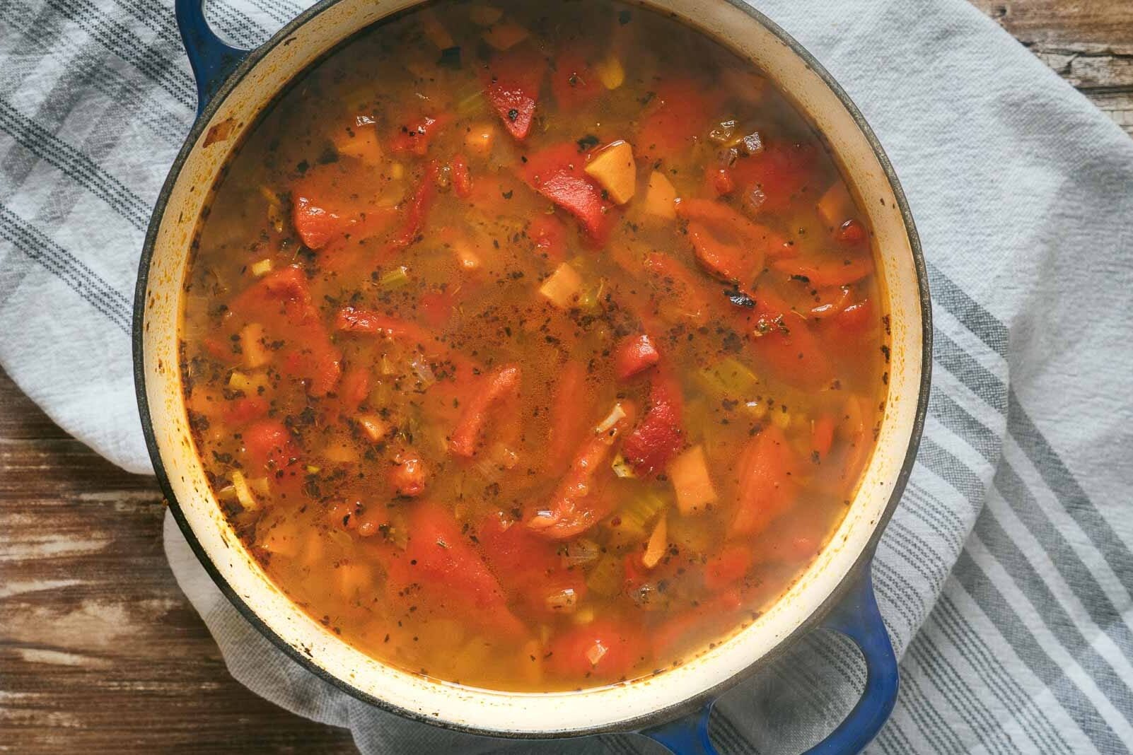 soup simmering with chunky red peppers.